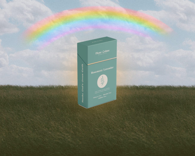 Fleur Calme herbal cigarette box on grass field with rainbow in sky.